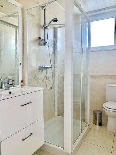 une salle de bain blanche avec douche et toilettes dans l'établissement Elysium Lodges, à Amnéville