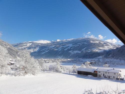 a snow covered mountain with a building in the foreground at Apart Alpensonne in Zellberg