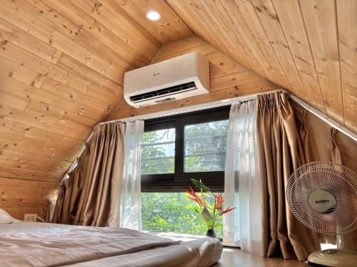 a bedroom with a wooden ceiling with a window and a fan at Tony Villa Homestay Ba Vì in Ba Vì