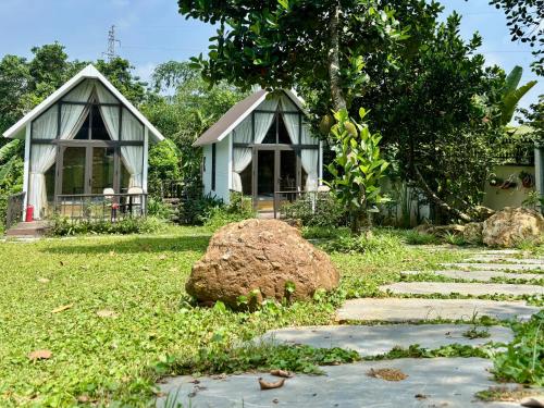 two small houses in a yard with a stone path at Tony Villa Homestay Ba Vì in Ba Vì