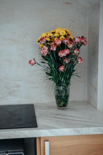 a vase filled with flowers sitting on a counter at Gorczańska Sapałówka in Maniowy