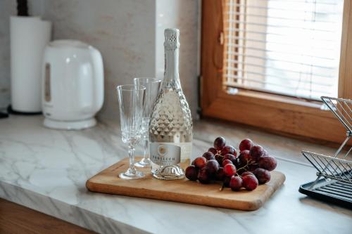 a bottle of wine and glasses on a cutting board at Gorczańska Sapałówka in Maniowy