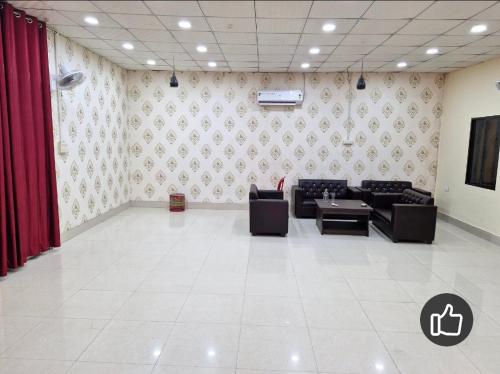 a living room with couches and a tv in a room at SAMURAI farm & RESORT in Jaipur