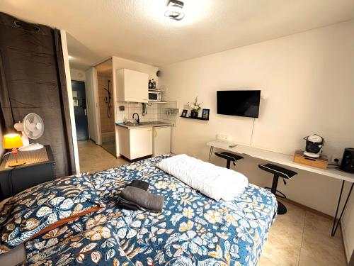 une chambre avec un lit et un bureau et une cuisine dans l'établissement Les Logis de Paray Appartement 201, à Paray-le-Monial