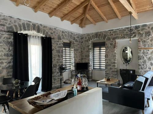 a living room with stone walls and a table at Stone House 1909 Pili Evia in Pili