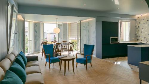 a living room with a couch and a table and chairs at Homingarda Apartments, Pool & Garden, Near Lake Garda and Center in Peschiera del Garda