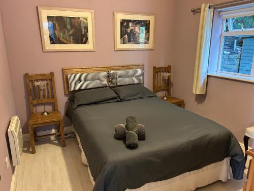 una camera da letto con un letto con un orsacchiotto sopra di Milkwood Cottage a Corwen