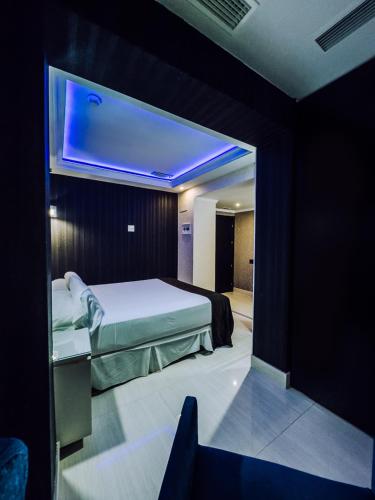 a bedroom with a bed with a blue ceiling at Hotel Años 50 in Torremolinos