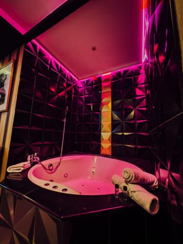 a pink bathroom with a tub with a purple lighting at Hotel Años 50 in Torremolinos