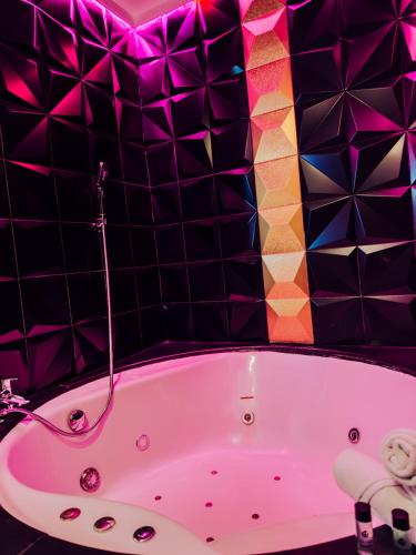 a pink bath tub in a bathroom with purple tiles at Hotel Años 50 in Torremolinos