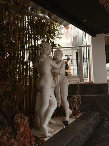 a statue of two people standing next to a window at Hotel Años 50 in Torremolinos