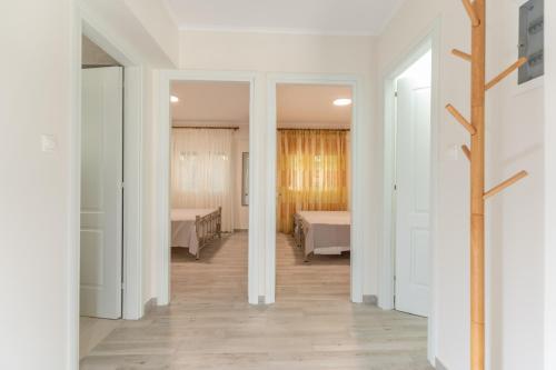 a room with two beds and a hallway with white walls at Luxury apartment in Chios 2 in Chios