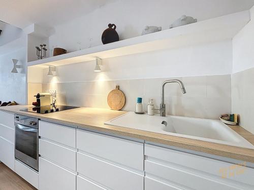 une cuisine blanche avec un évier et une cuisinière dans l'établissement Hyper Centre Vieux Port - Loft - Les Frères de la Loc', à Marseille