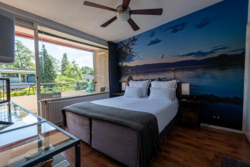a bedroom with a large bed and a large window at Benvenuto in The Hague