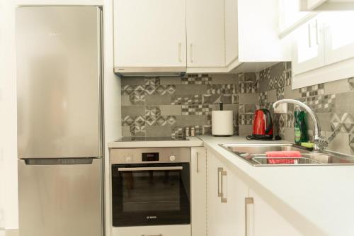 a kitchen with white cabinets and a stainless steel refrigerator at Luxury apartment in Chios 2 in Chios