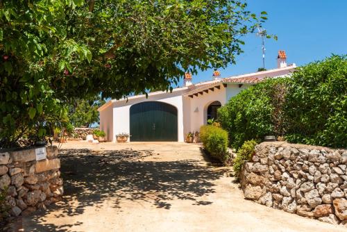 a house with a gate and a stone wall at Villa La Martina in Sant Lluis