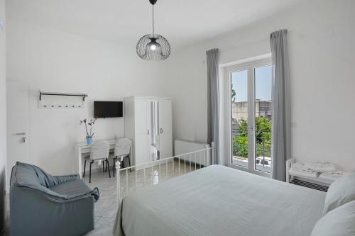 a white bedroom with a bed and a dining room at Grimaldi Rooms in Pagani