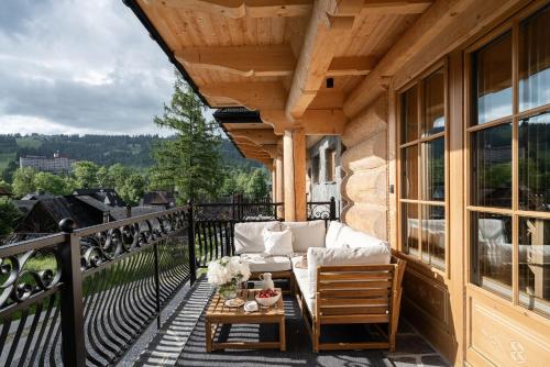 a porch with a couch and a table on a balcony at Bacówka Chalet in Zakopane