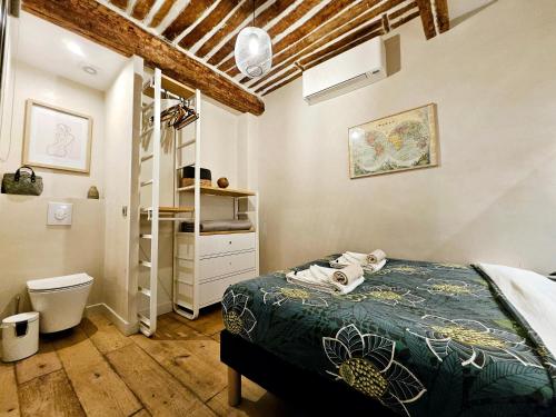 a bedroom with a bed and a toilet in a room at La Fourmilière - dans le Vieil Antibes in Antibes