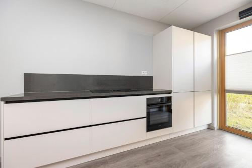 a kitchen with white cabinets and a black oven at Residence Dordrecht in Dordrecht