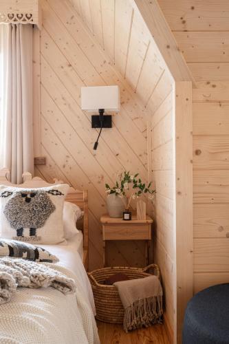 a bedroom with a bed in a wooden room at Bacówka Chalet in Zakopane