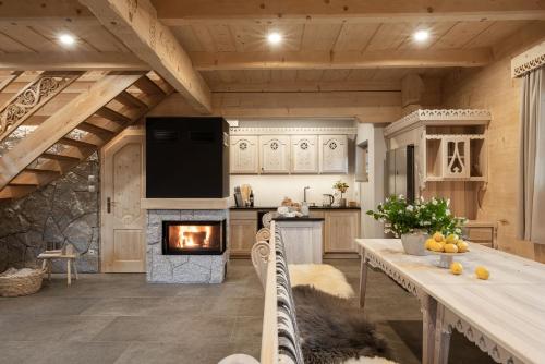 a kitchen with a fireplace and a table and a stove at Bacówka Chalet in Zakopane