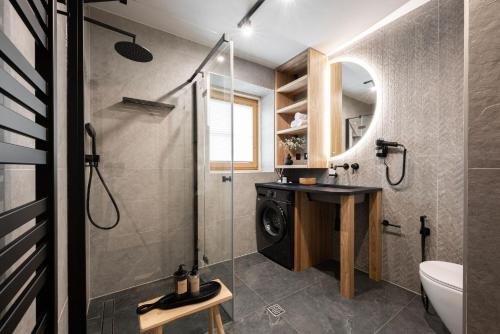 a bathroom with a shower and a washing machine at Bacówka Chalet in Zakopane