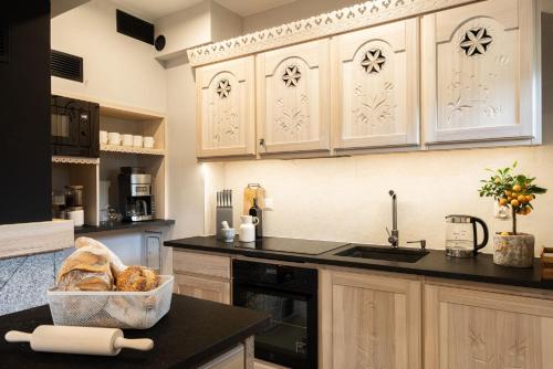 a kitchen with white cabinets and a black counter top at Bacówka Chalet in Zakopane