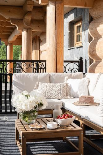 a white couch on a porch with a coffee table at Bacówka Chalet in Zakopane
