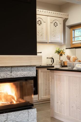 a kitchen with a stove with a fire in the oven at Bacówka Chalet in Zakopane