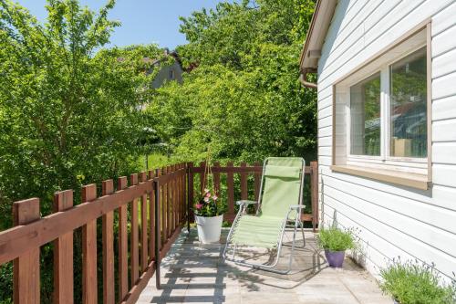 a green lawn chair sitting on a fence at Aux Mirabelles Chez Florence Thierry in Bussang