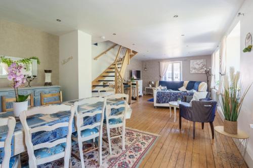 a living room with a table and chairs and a staircase at Aux Mirabelles Chez Florence Thierry in Bussang