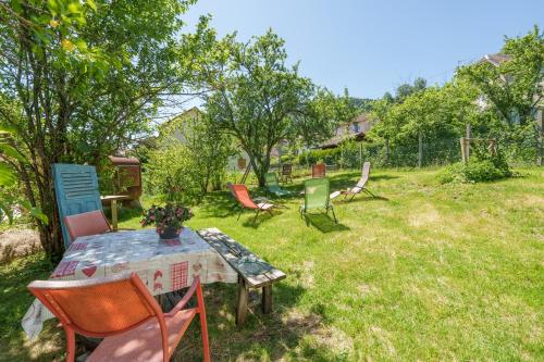 a group of chairs and a table in a yard at Aux Mirabelles Chez Florence Thierry in Bussang