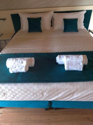 two towels are sitting on the bottom of a bed at 4 Elementi Relais B&B Lonato del Garda in Lonato del Garda