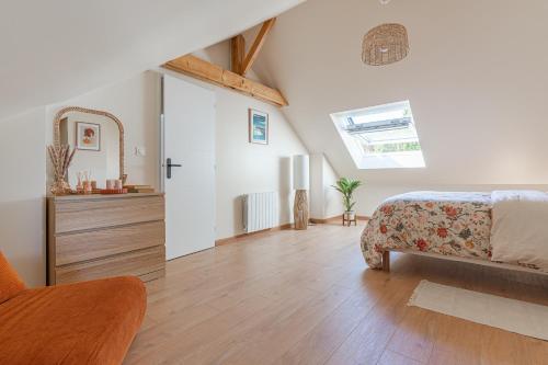 a bedroom with a bed and a dresser in a room at La Maison du Martrait - Proche de la plage in Graye-sur-Mer