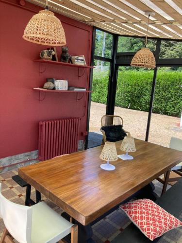 a wooden table with two lamps and chairs at Chez Henriette - Maison à 10min du circuit des 24h in Changé