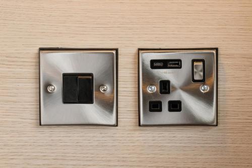two light switches sitting on top of a wall at Garner Hotel Edinburgh - Haymarket by IHG in Edinburgh