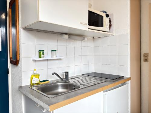 a kitchen with a sink and a microwave at T2 23m2 Confort calme Centre ville Paray app 408 in Paray-le-Monial