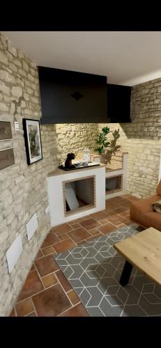 a living room with a fireplace and a stone wall at Avalon in Setenil in Setenil