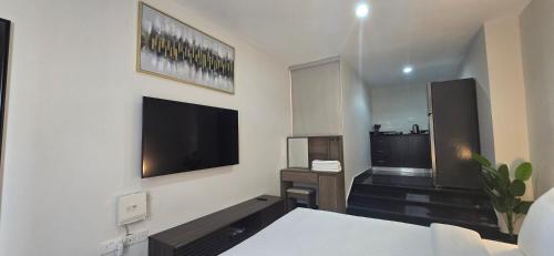 a bedroom with a bed and a tv on a wall at Nasma Homes in Abu Dhabi