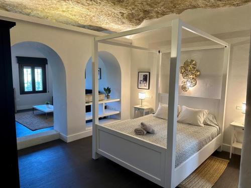 a bedroom with a canopy bed with a ceiling at Avalon in Setenil in Setenil