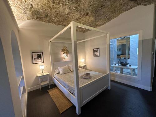 a bedroom with a canopy bed and a bathroom at Avalon in Setenil in Setenil