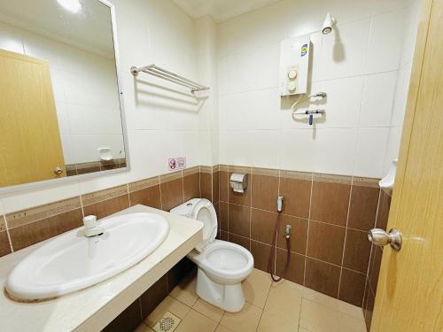 a bathroom with a sink and a toilet and a mirror at Hotel O Tasik Utama in Malacca