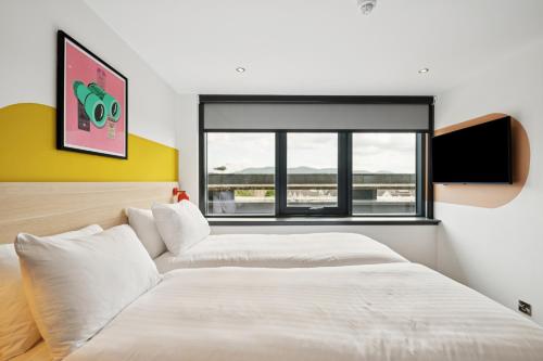 a bedroom with two beds and a window at Garner Hotel Edinburgh - Haymarket by IHG in Edinburgh