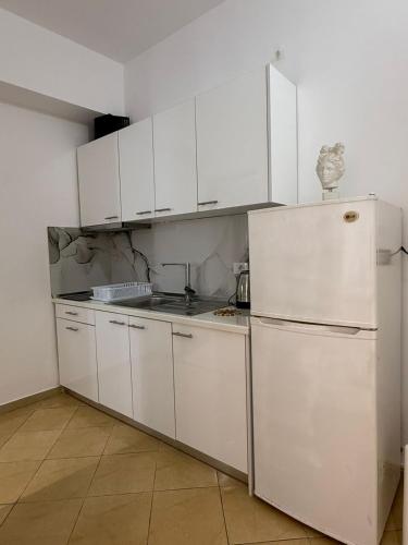 a kitchen with white cabinets and a refrigerator at Vila Dena in Vlorë