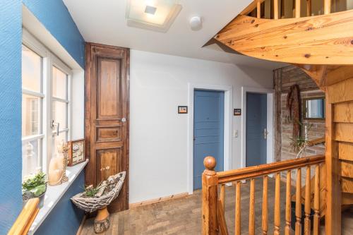 a room with a wooden staircase with a blue wall at Hochzeitskoje - Gemütliche Ferienwohnung im Fischerhaus, zentral & hundefreundlich in Waren