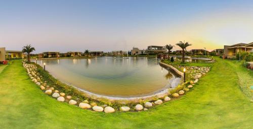 a large pond in the middle of a yard at Araiya Gir,A Mavintara Resort in Chitrāwal