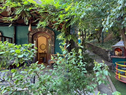 a house with a door and a yard with trees at Vila Eden Boutique Hotel in Korçë