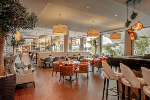 a restaurant with chairs and tables and a bar at Courtyard by Marriott Munich City Center in Munich