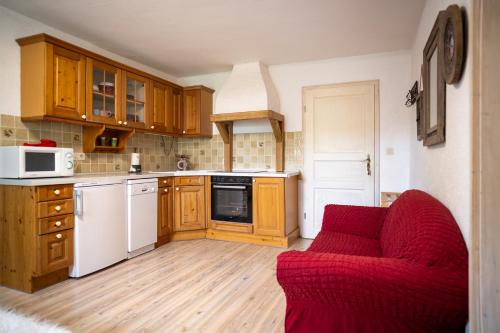 a kitchen with a red couch in a room at Stadlerhof Alpen- & Seeblick in Kirchanschöring